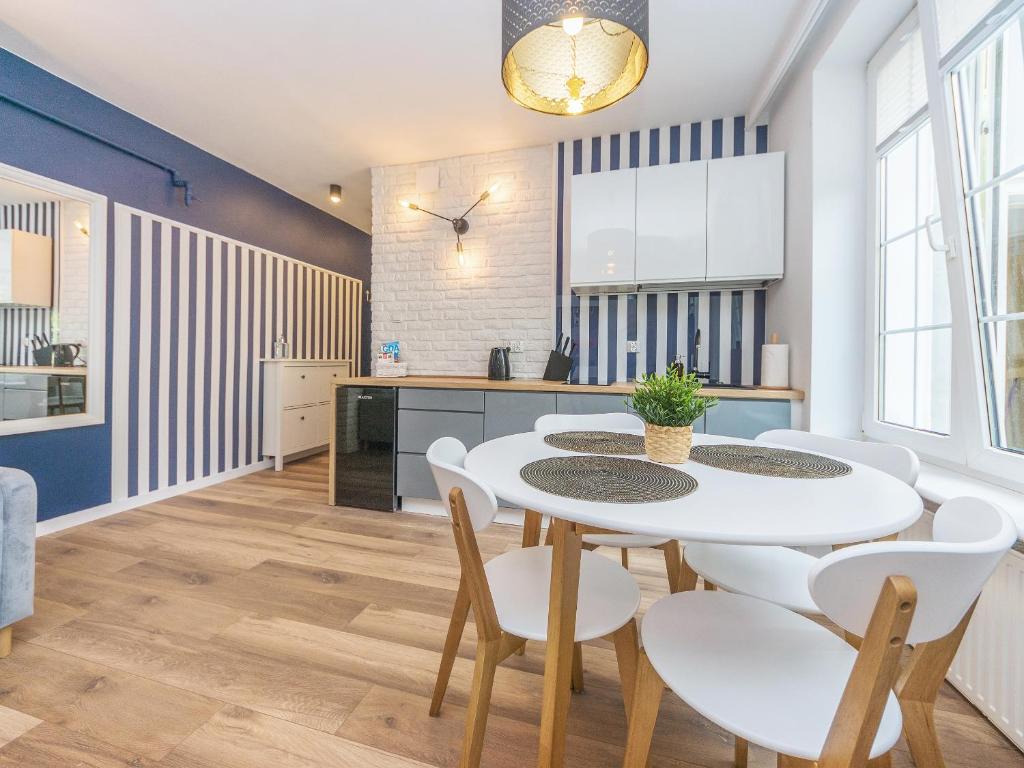 uma cozinha e sala de jantar com uma mesa branca e cadeiras em Glow Apartments, Apartament Długa 69 em Gdansk