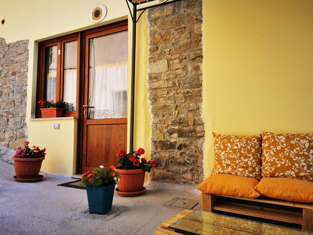eine Couch vor einem Gebäude mit Topfpflanzen in der Unterkunft Agriturismo B&B Il Girasole in Roccadaspide