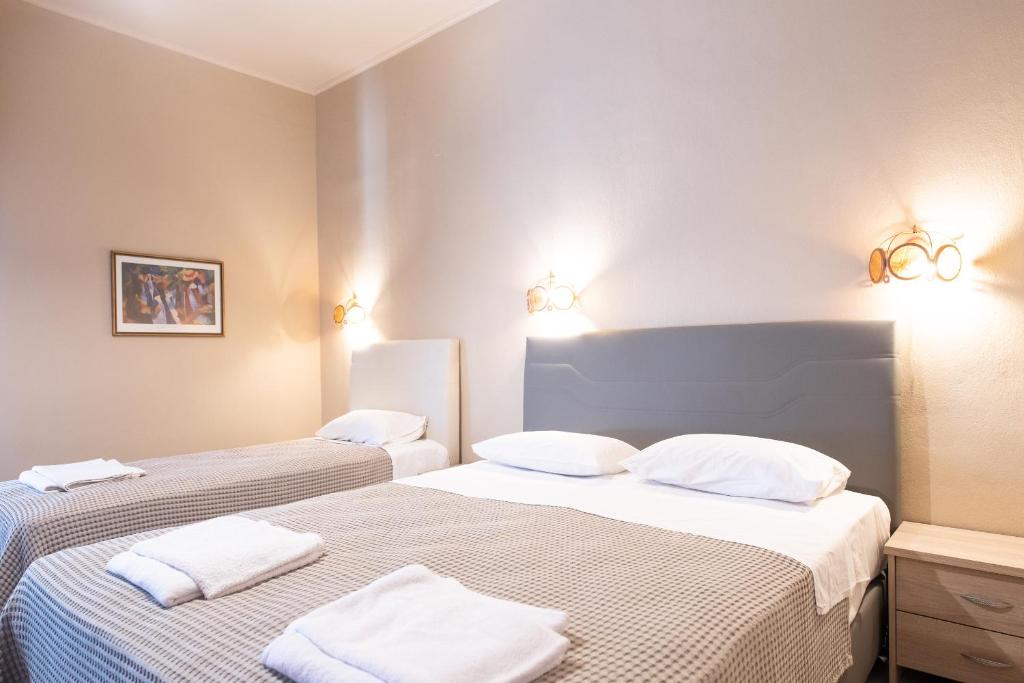 Yannis Hotel في Krinídhes: سريرين في غرفة مع وسائد بيضاء