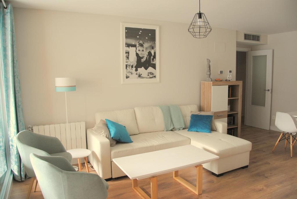 sala de estar con sofá, mesa y sillas en Apartamento Dulcinea en Alcalá de Henares
