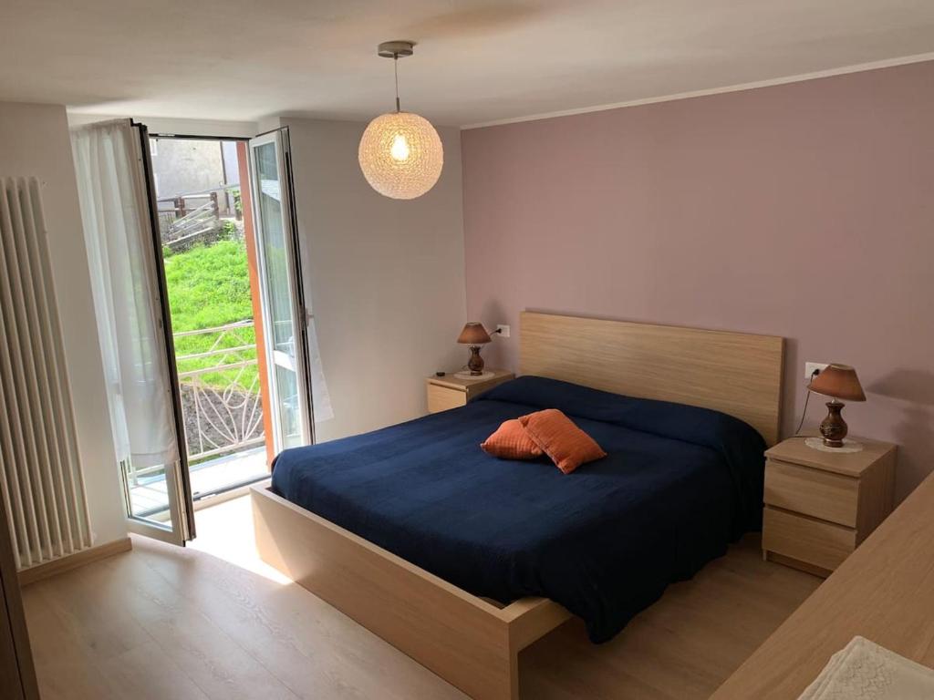 a bedroom with a blue bed and a window at Da Giulia e Pietro Antonio in Pianazzo