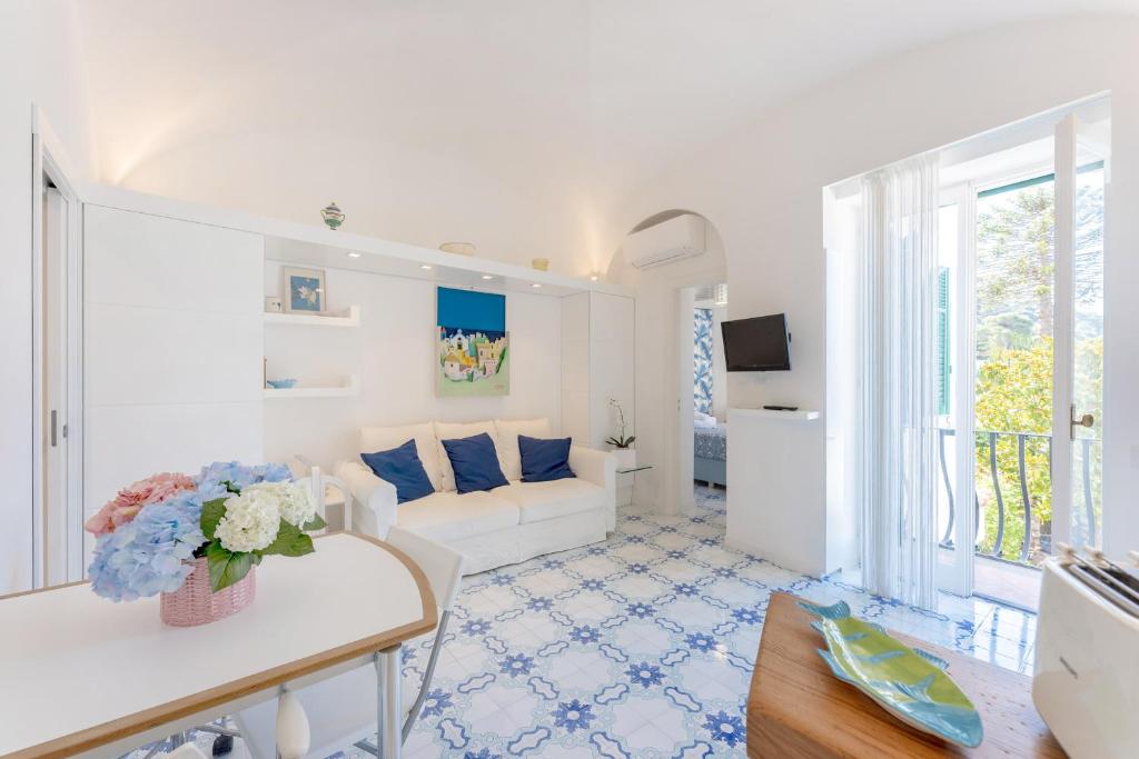 Azzurra, Capri في كابري: غرفة معيشة بيضاء مع أريكة وطاولة