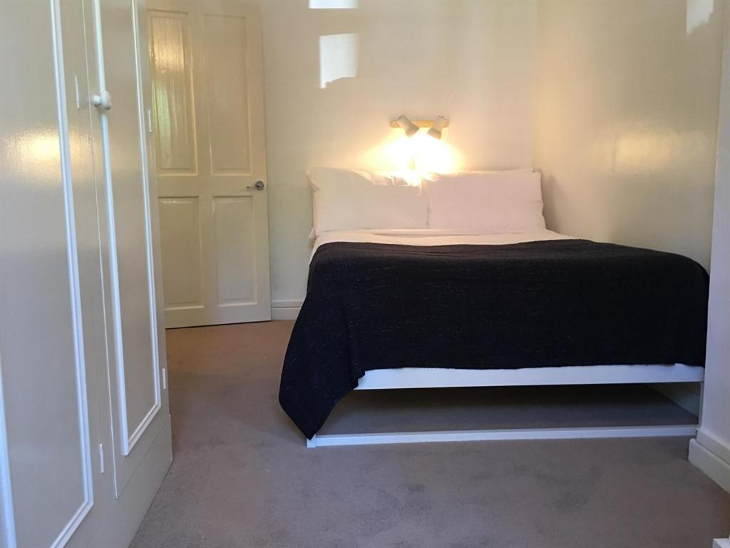 ロンドンにあるマーブル アパートメンツ エフラ コートのベッドルーム1室(ライト付)