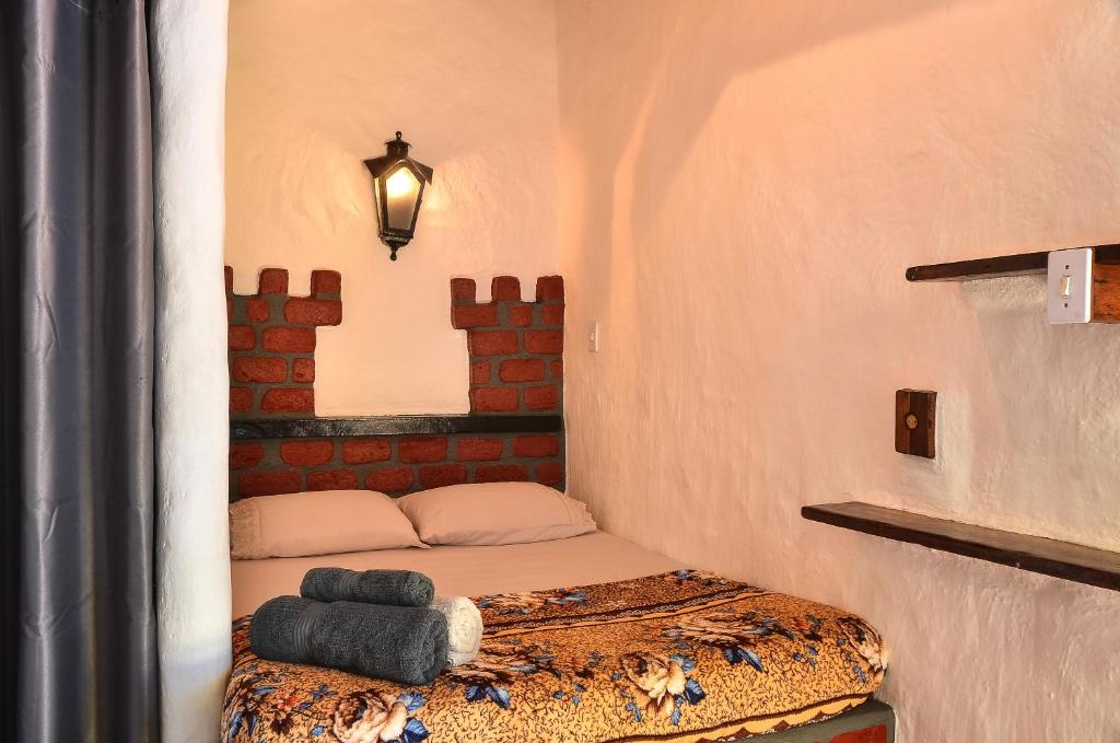 - une petite chambre avec un lit dans l'établissement Ready Camp e Suítes da Cachoeira, à Abraão