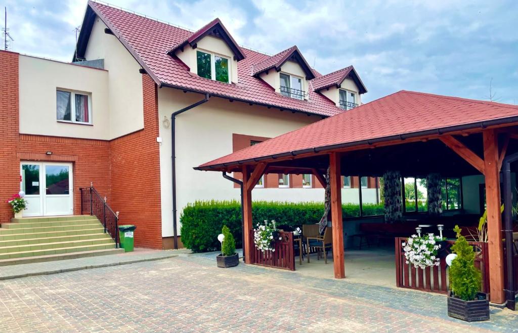 比斯庫平的住宿－Przystań Biskupińska，一座带红色屋顶和庭院的房子