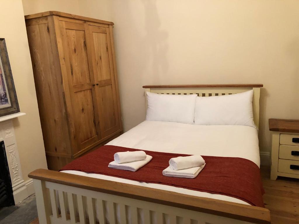 a bedroom with a bed with two towels on it at Marble Apartments Tooting Broadway in London