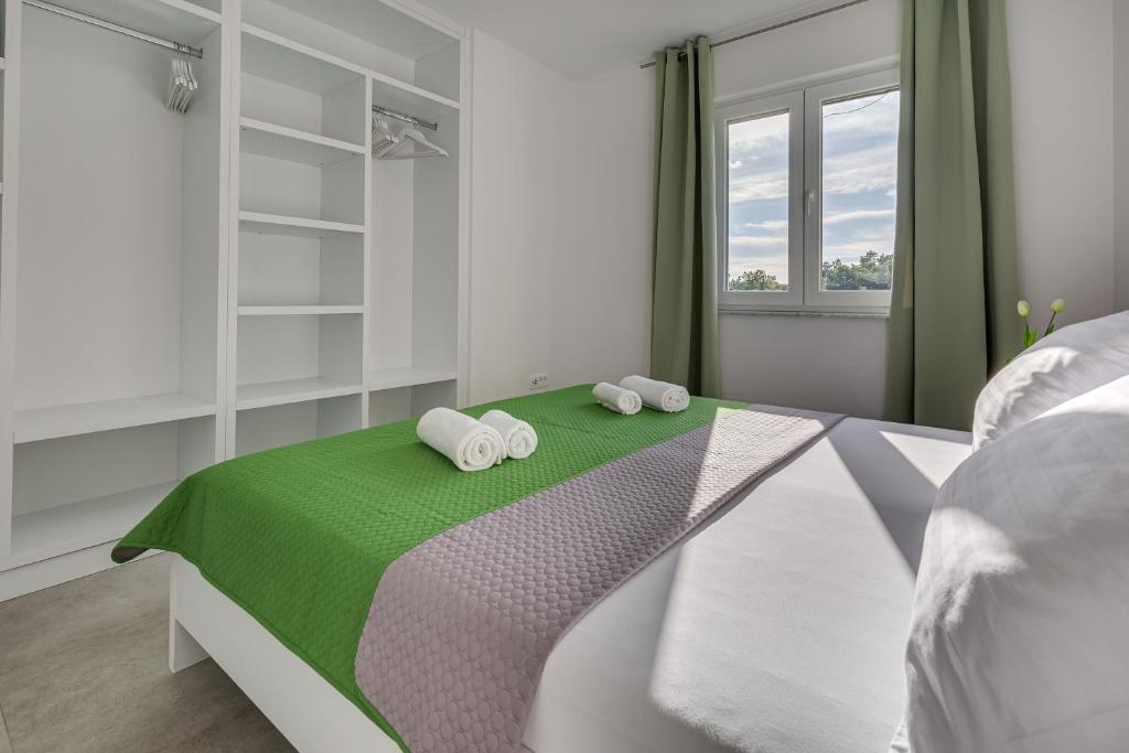 ein Schlafzimmer mit einem Bett mit zwei Handtüchern darauf in der Unterkunft Green Point Paklenica in Starigrad-Paklenica