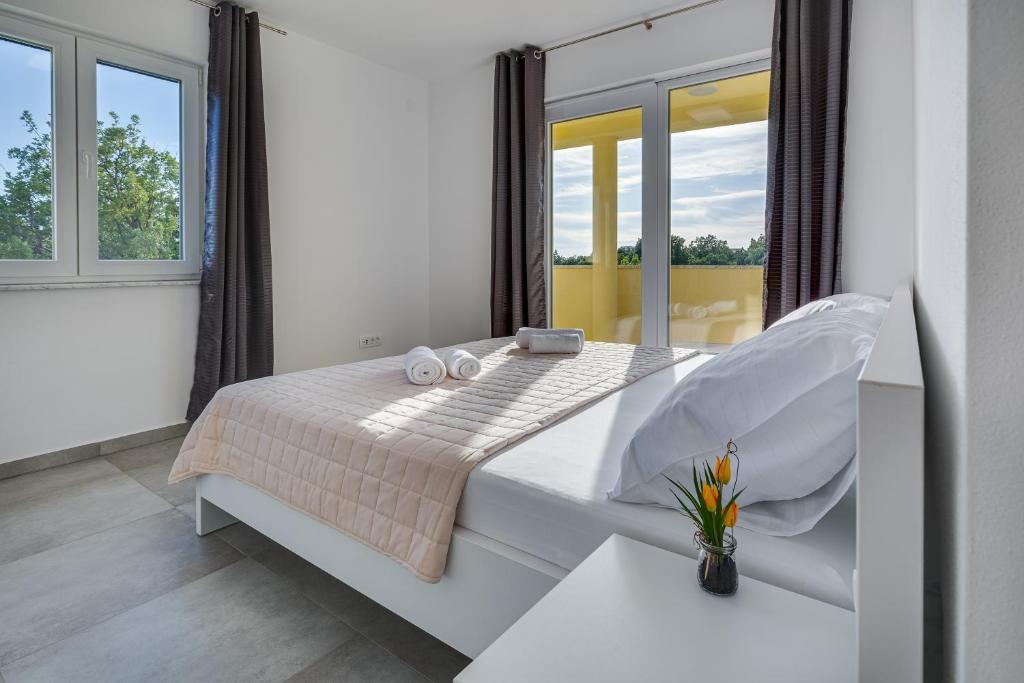 ein Schlafzimmer mit einem weißen Bett und einem Fenster in der Unterkunft Green Point Paklenica in Starigrad-Paklenica