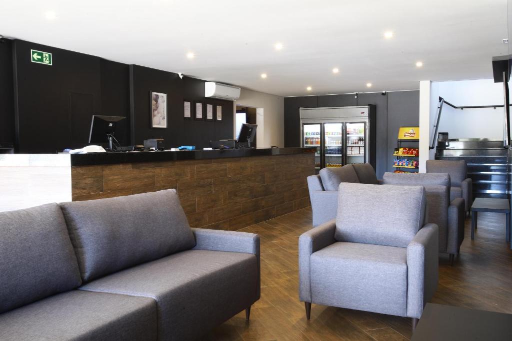 a living room with couches and chairs and a bar at Hotel Pro Tork Confort in Santo Antônio da Platina