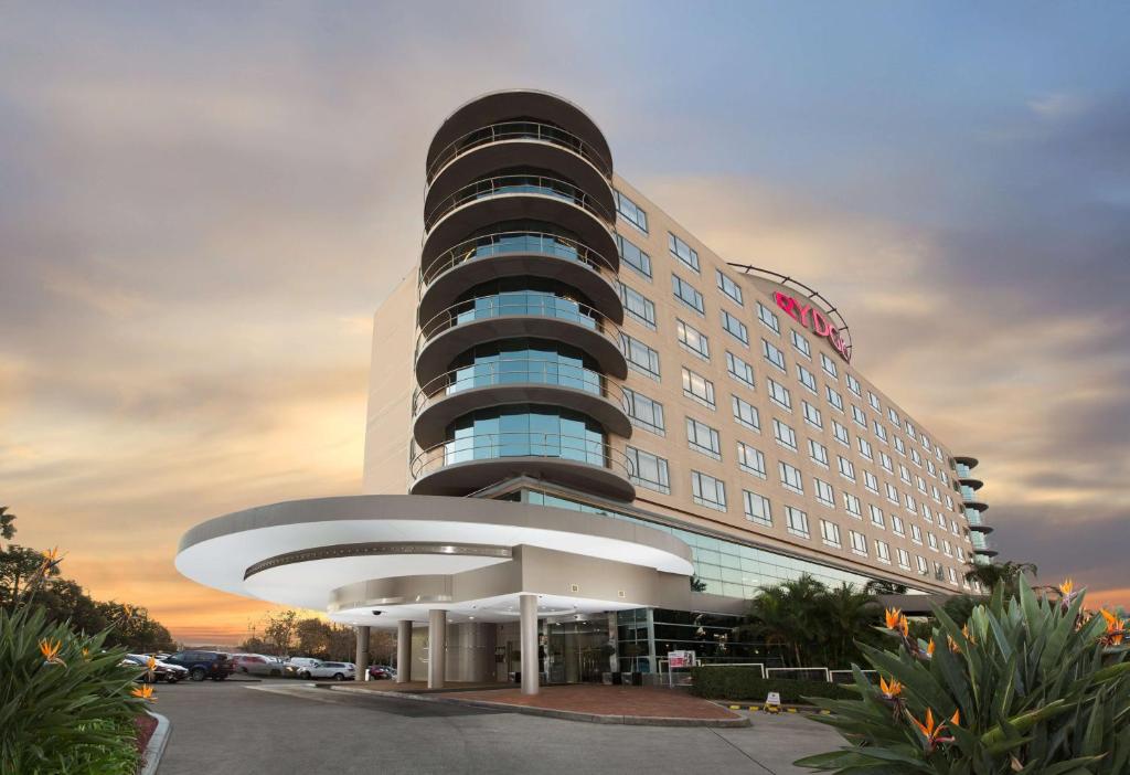 ein großes Hotelgebäude mit einem runden Gebäude in der Unterkunft Rydges Parramatta in Sydney