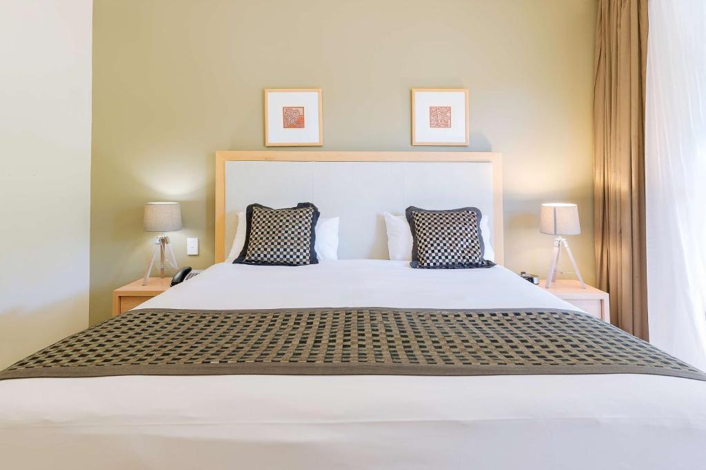 a bed with a white comforter and pillows at Rydges Kalgoorlie in Kalgoorlie