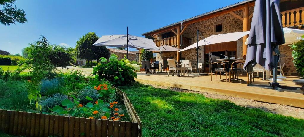 un jardin en face d'un bâtiment avec des parasols dans l'établissement Domaine de la Plagnette, à Les Salles