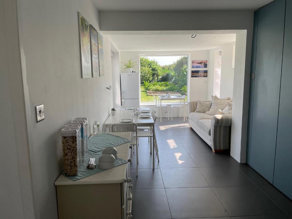 a kitchen and living room with a couch and a table at Cottars in Winfrith Newburgh