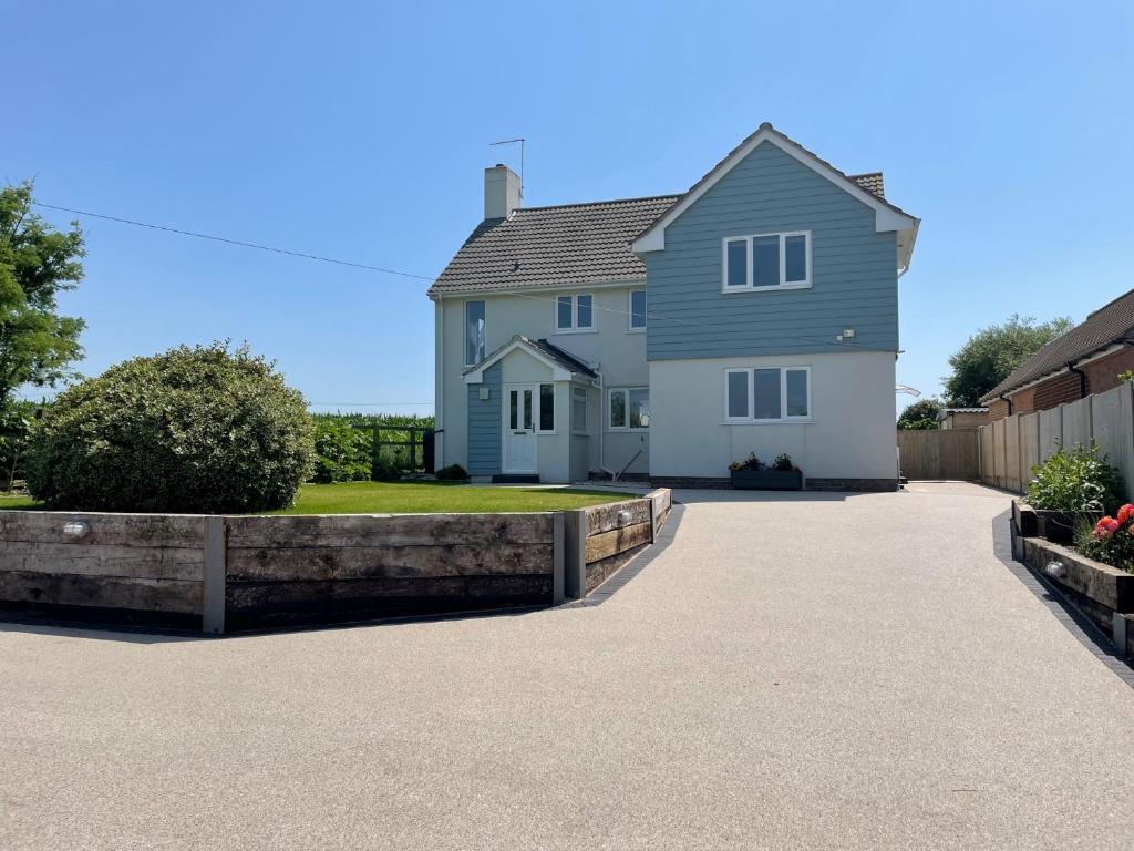 a white house with a fence and a driveway at Cottars in Winfrith Newburgh