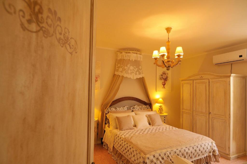 sypialnia z łóżkiem i żyrandolem w obiekcie Vacanze Romantiche a Modica w mieście Modica