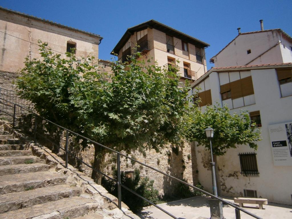 an old building with a tree next to some stairs at Casa Placet de Sant Joan Apto in Morella