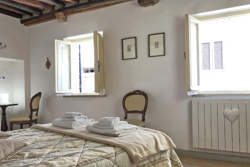 1 dormitorio con 1 cama con toallas en Alberi Flat, en Volterra