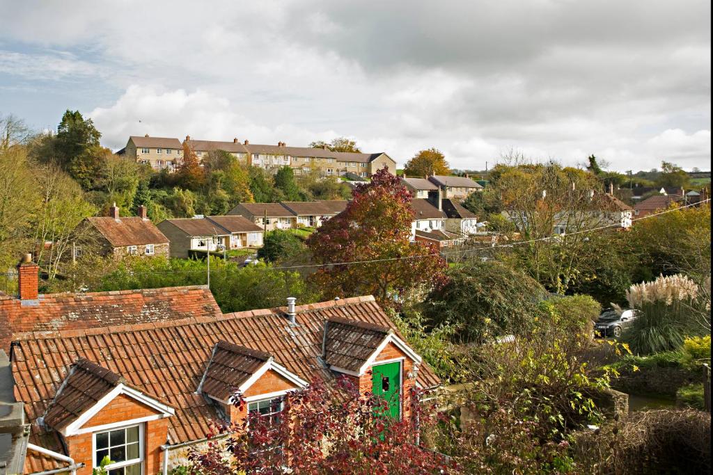 a group of houses in a town with a green door at Turks Hall in Bruton