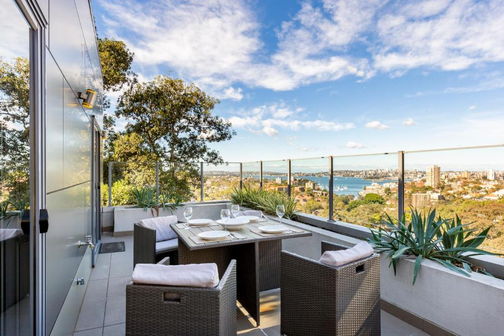an outdoor patio with a table and chairs on a balcony at 2 Bdrm North Sydney with stunning harbour views - 16WAL in Sydney
