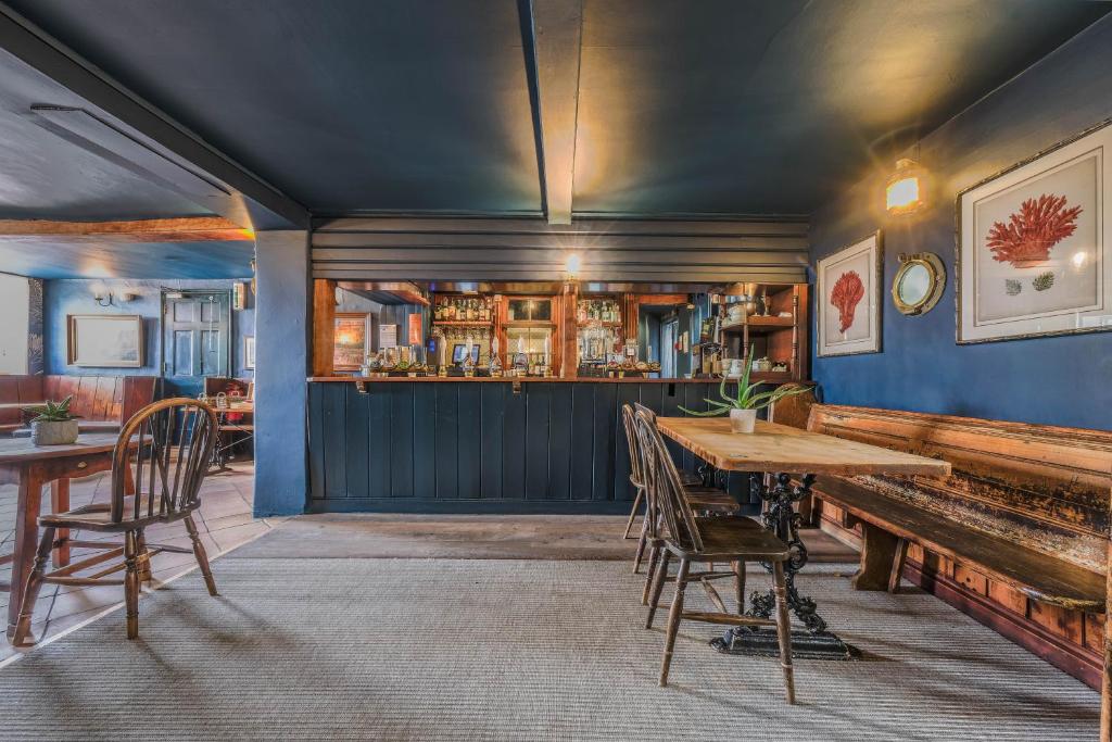 a dining room with a table and a bar at The Ship At Dunwich in Dunwich