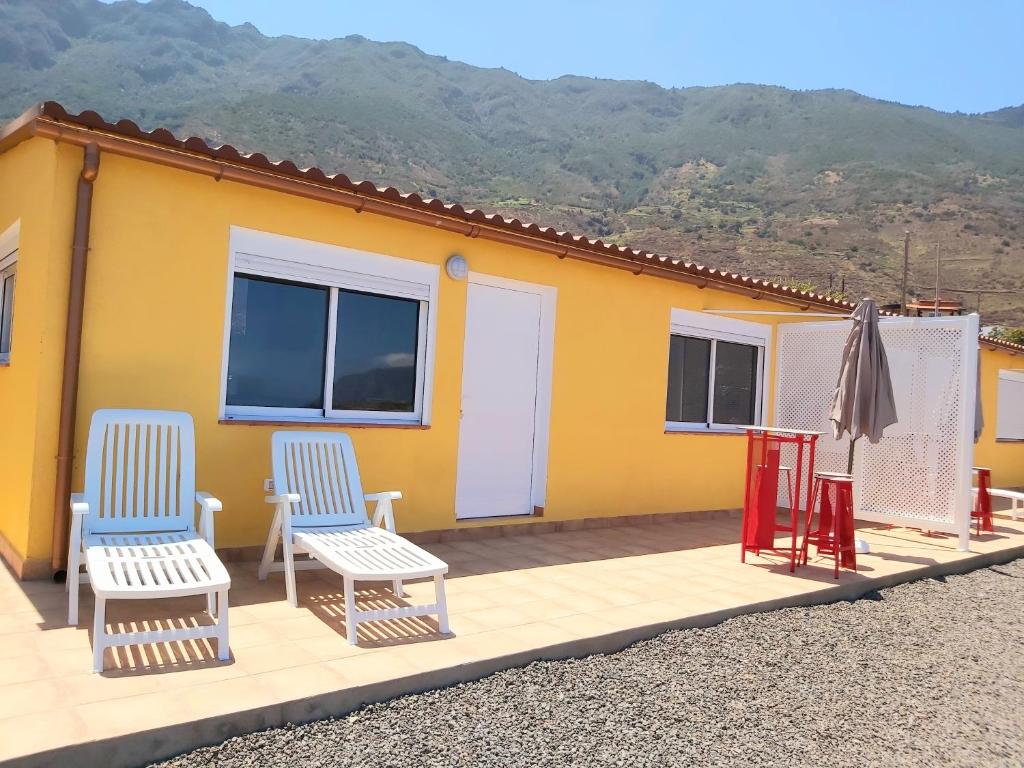 una casa con due sedie e un ombrellone su un ponte di Vista al Mar a Frontera