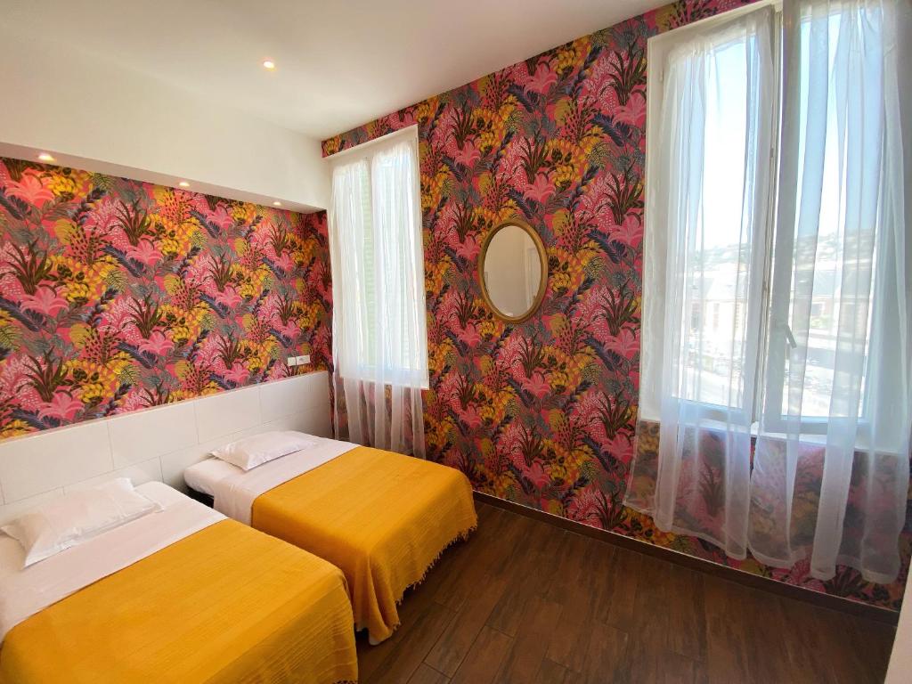 Duas camas num quarto com papel de parede floral em Interlaken em Nice