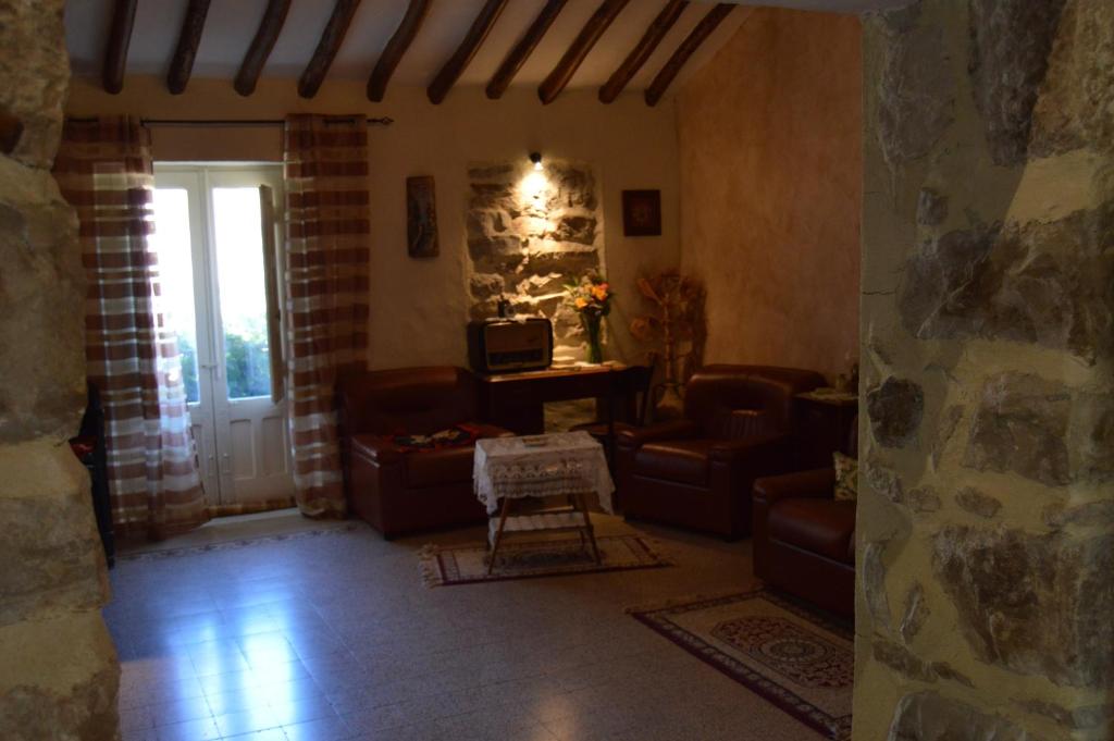 ein Wohnzimmer mit Ledermöbeln und einer Steinmauer in der Unterkunft Casa "Albero Verde" in Raffo
