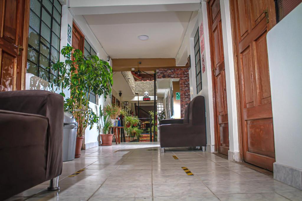 un couloir d'un bâtiment avec des chaises et des plantes dans l'établissement Hotel Virgen del Carmen - Huaraz, à Huaraz