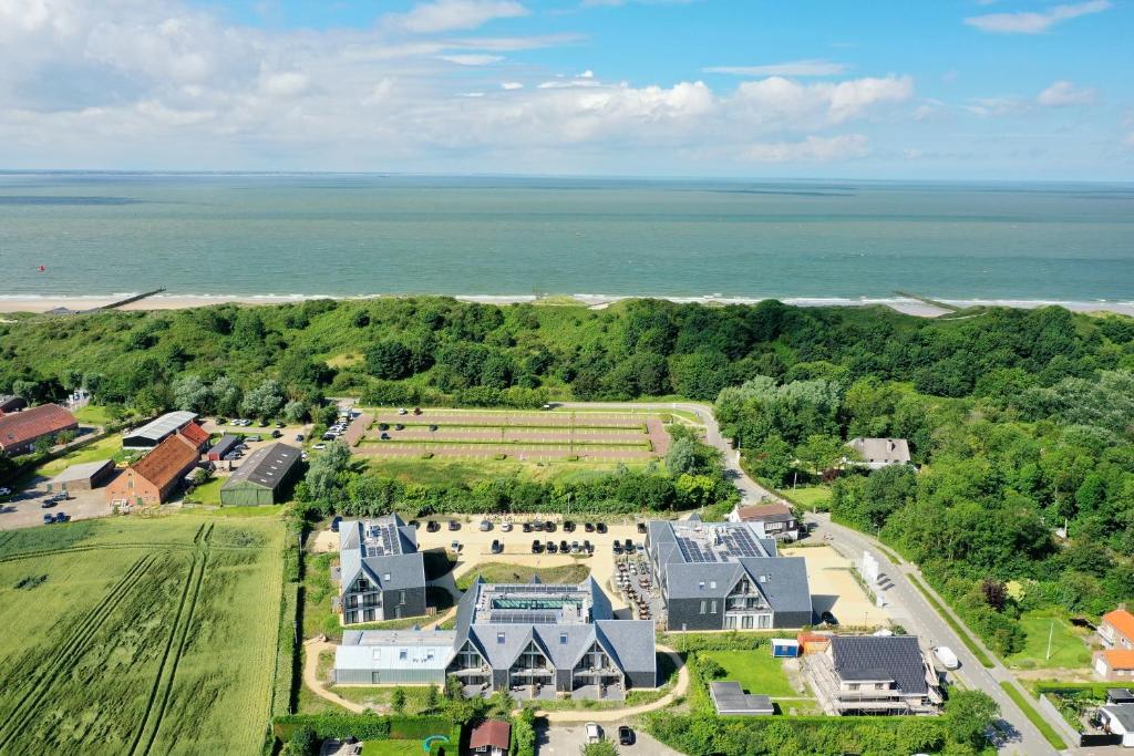 an aerial view of a large house with the ocean at Hotel Zeeuws Licht I Kloeg Collection in Dishoek