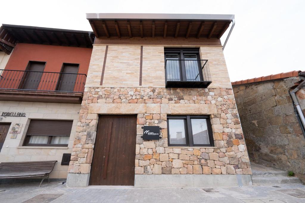 um edifício de tijolos com uma porta e uma varanda em Hotel Rural La Casa de Mis Abuelos em Navaleno