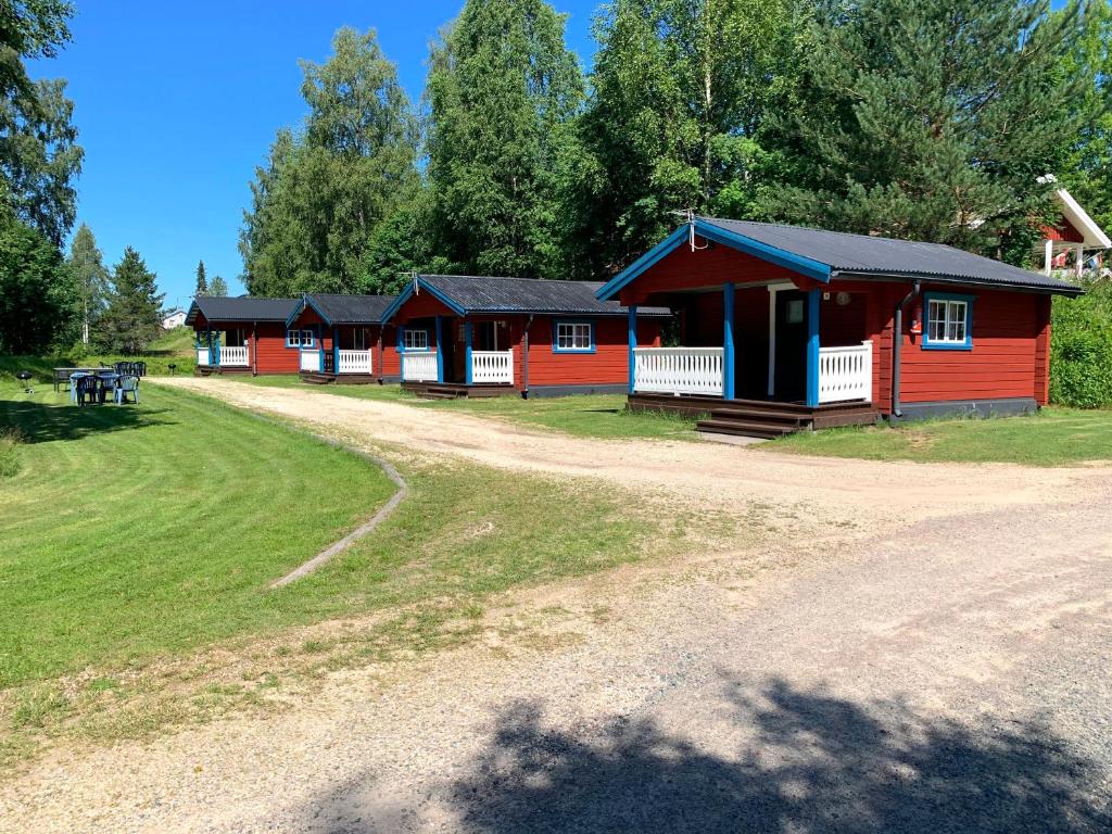 uma fila de cabanas vermelhas numa estrada de terra batida em Värnäs Camping em Stöllet