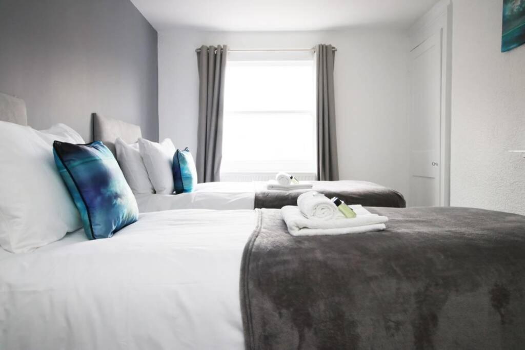 a hotel room with two beds with towels on them at Spacious Georgian 3bedroom Apartment, 5 mins from Bath Abbey in Bath