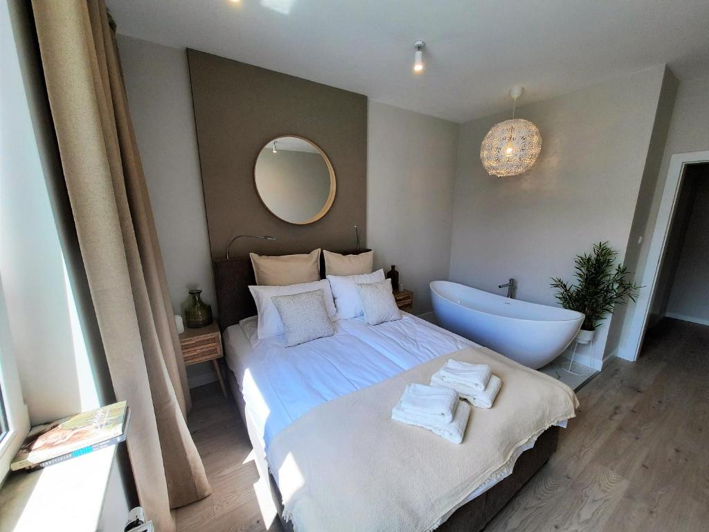 sypialnia z dużym łóżkiem i wanną w obiekcie PLUSK Apartments Mrągowo w mieście Mrągowo