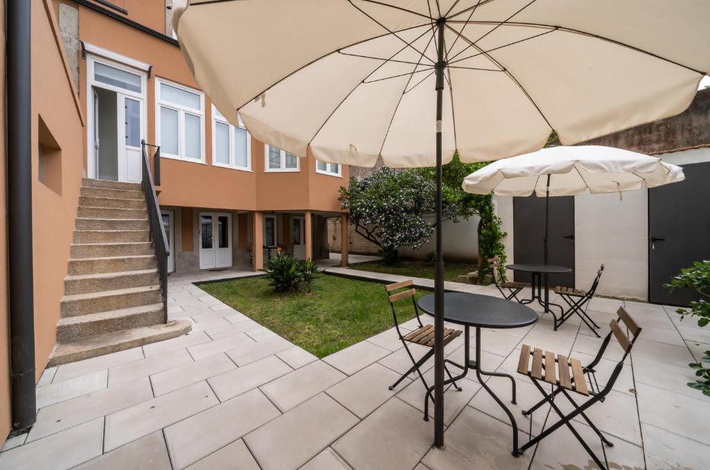 a patio with an umbrella and a table and chairs at CASA RIETSCH in Matosinhos