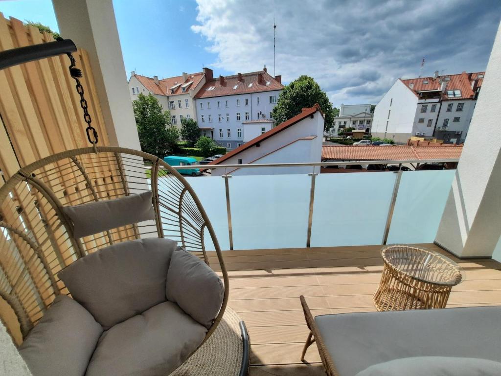 krzesło na balkonie z widokiem na miasto w obiekcie PLUSK Apartments Mrągowo w mieście Mrągowo
