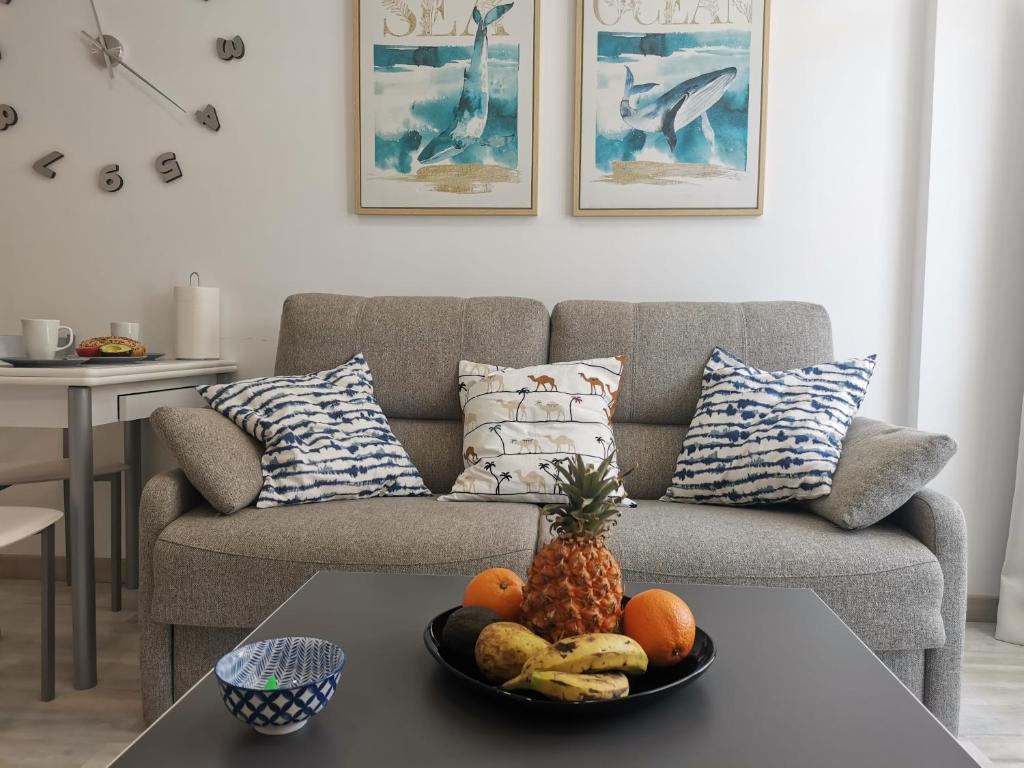 una sala de estar con sofá y un bol de fruta en una mesa en SUNNY CACTUS GARDEN Apartment 150m from beach, fast Fiber Wifi en San Bartolomé