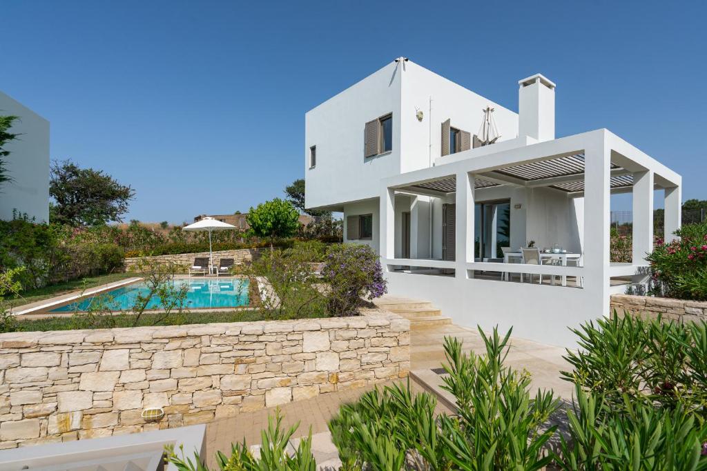 a villa with a swimming pool and a house at Sofia Luxury Villas in Panormos Rethymno