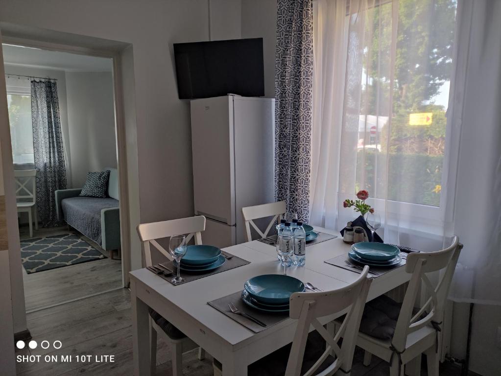 Apartamenty Mewa في مينززدرويه: طاولة غرفة الطعام مع الأطباق الزرقاء عليها