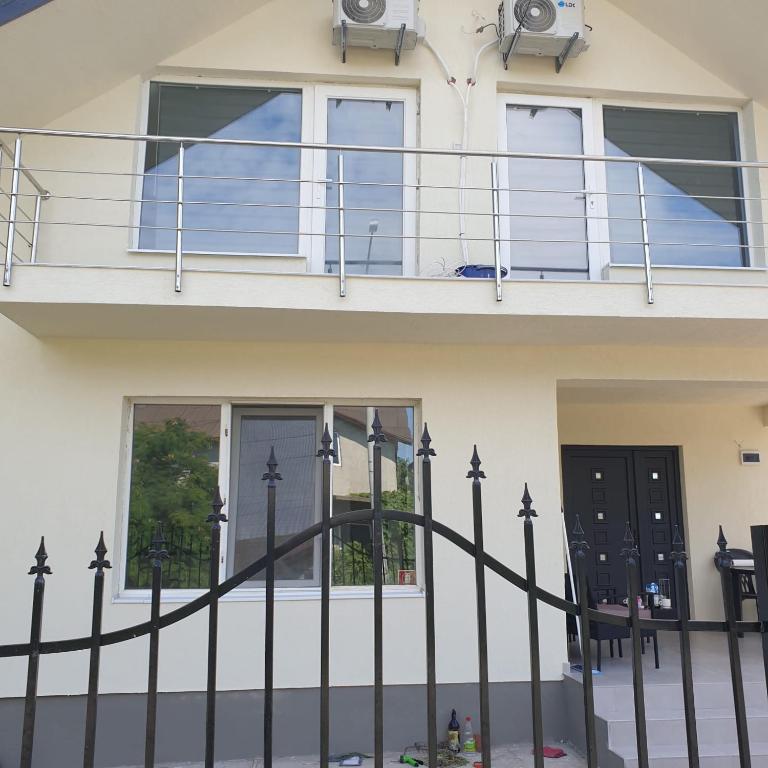 ein Haus mit einem Balkon und einem schmiedeeisernen Zaun in der Unterkunft Casa Margareta in Eforie Sud