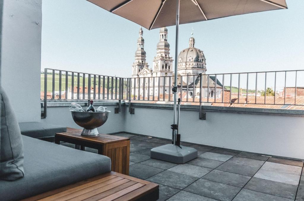 a room with a balcony with a view of the city at Altstadt Hotel Self Check-In in Würzburg