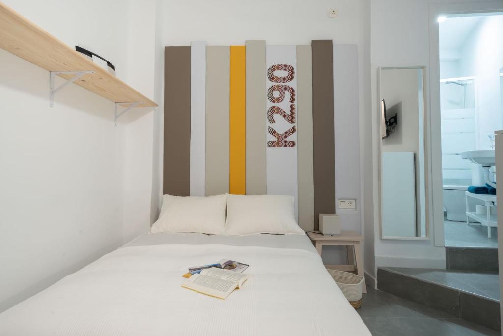 Un dormitorio con una cama con un libro. en NICE and COSY LOFTS CITY CENTER 1&2, en Málaga
