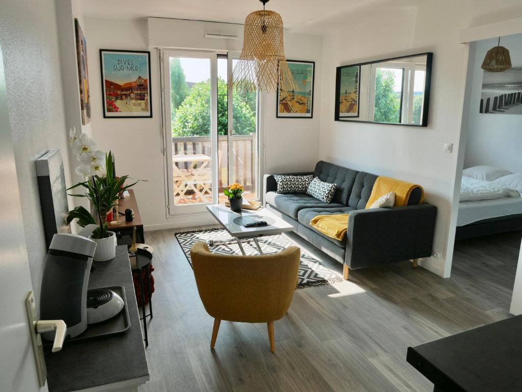 a living room with a couch and a table at Plage Cabourg 5bis in Cabourg