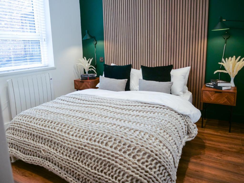 曼徹斯特的住宿－Afflecks by The Heim Residences，一间卧室设有一张带绿色墙壁的大床