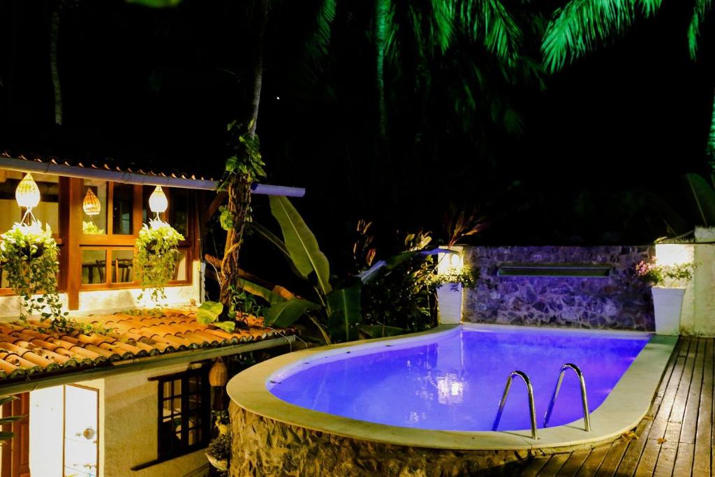 eine Whirlpool-Badewanne im Garten in der Nacht in der Unterkunft Qavi - Villa di Milos - Praia da Pipa in Pipa