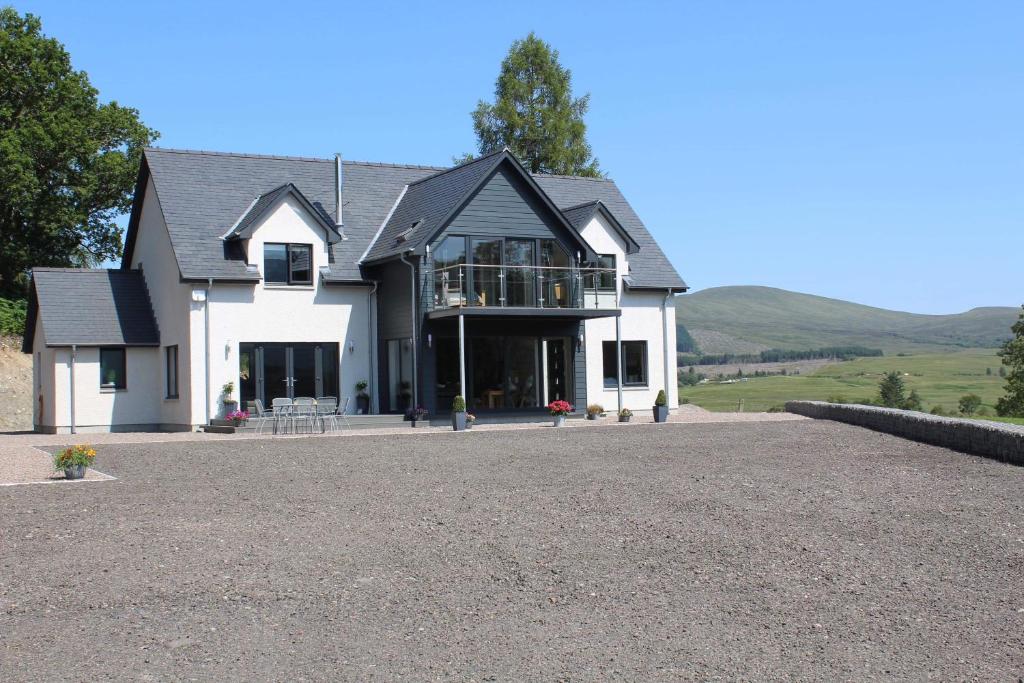 una grande casa bianca con un vialetto di ghiaia di Stag Lodge a Spean Bridge