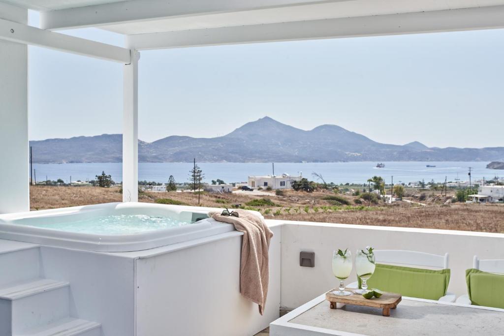 a bath tub on a balcony with a view of the ocean at Glarakia Studios in Adamas