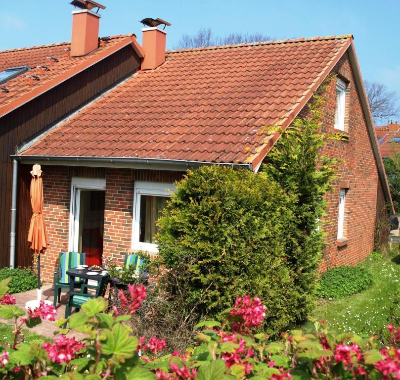 ボルテンハーゲンにあるUrlauberdorf 62aの赤い屋根と花のレンガ造りの家