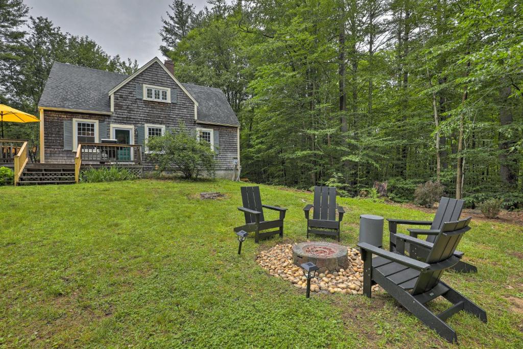 Charming Jaffrey Cottage with Deck and Grill! في Jaffrey: ساحة بها كرسيين وحفرة نار امام منزل