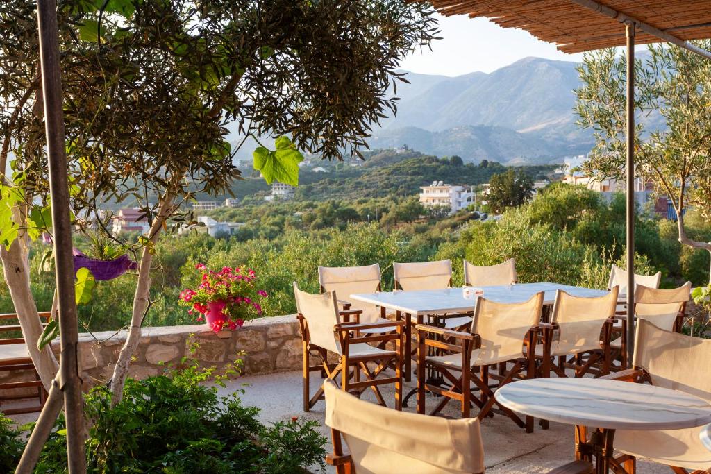 een tafel en stoelen met uitzicht op een berg bij Toni Retzo Rooms in Himare