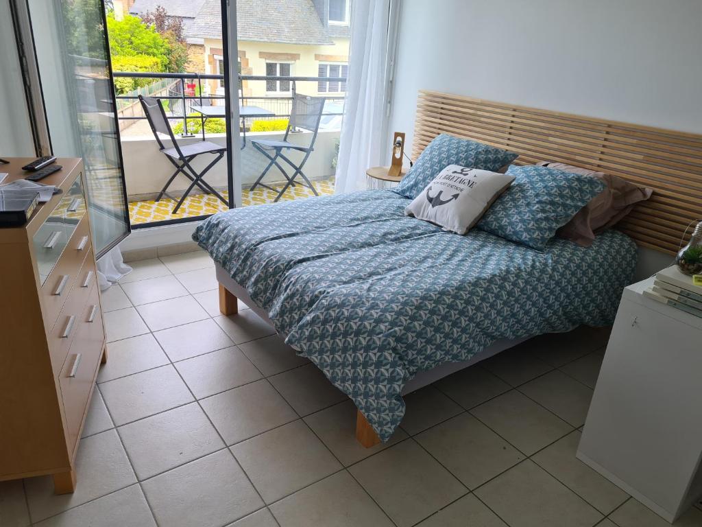 a bedroom with a bed and a view of a balcony at Chez Malo in Perros-Guirec